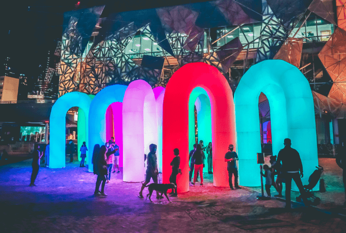 Simulated image of outdoor night scene at Glass Bottle with people in front of large illuminated entrances to a glass dome